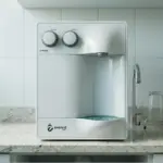 Purificador de água branco Everest com duas torneiras e dois copos de vidro sobre bancada clara, representando um modelo eficiente para economizar energia em casa.